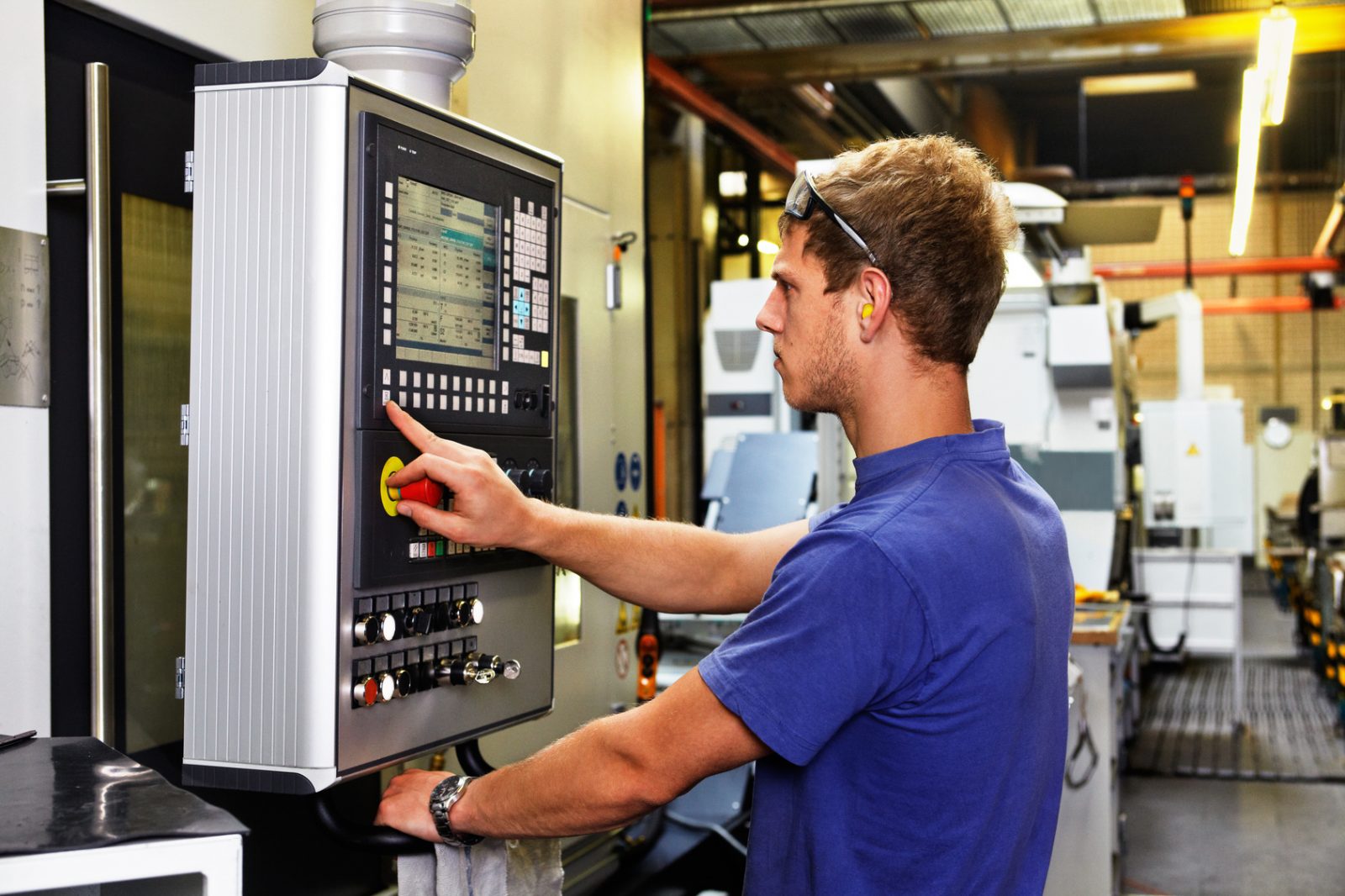 skilled worker controlling a digitally programmed machine tool